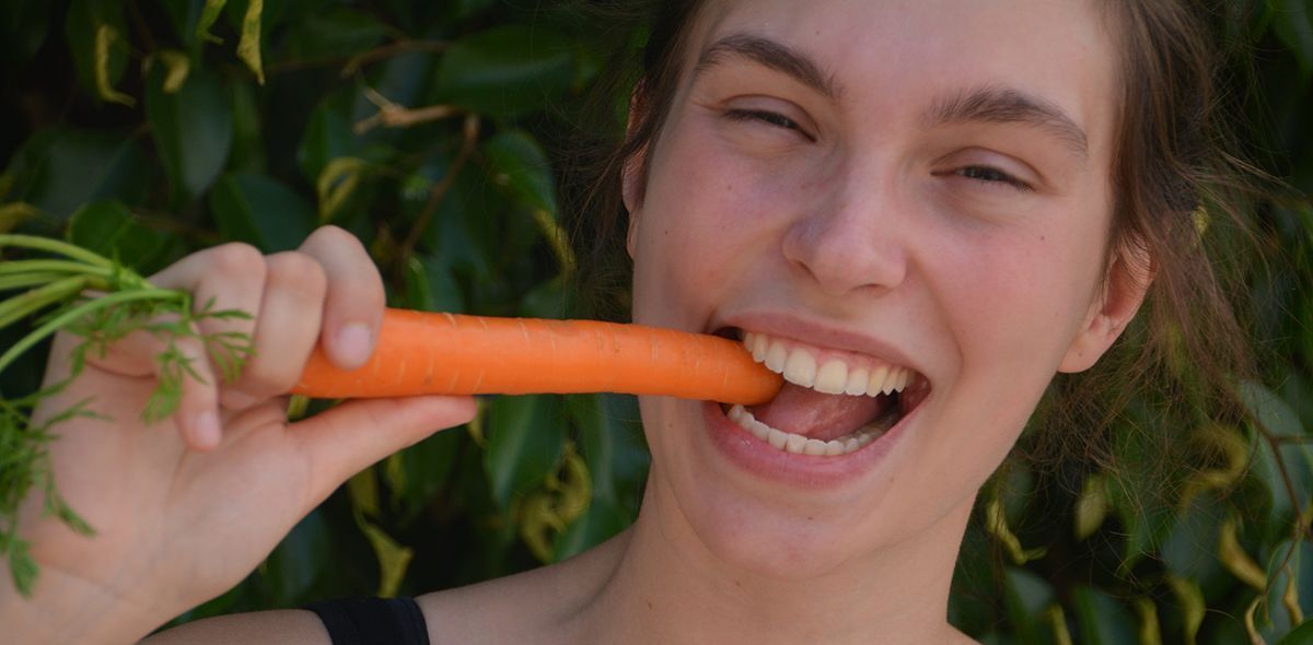Mädchen beißt in eine Karotte